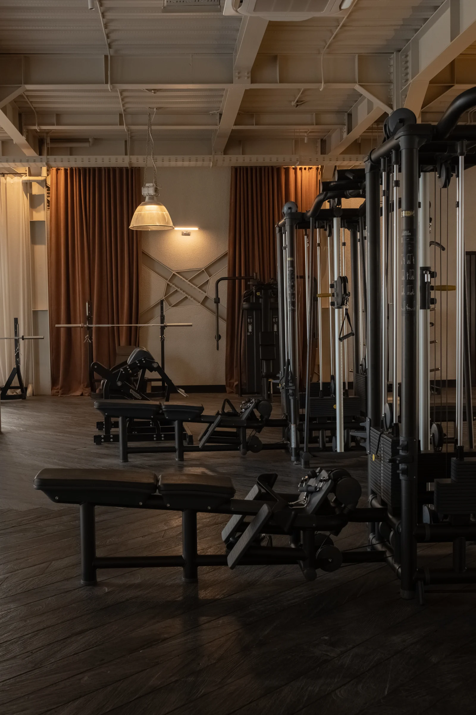 Cable machines and adjustable benches across the gym floor.